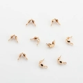 Macro detail of rose gold DIY jewelry folding crimp bead covers and metal cord ends - Copper