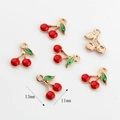 Macro detail of red and green enamel cherry charms for DIY jewelry making 13mm - 13mmx11mm / Cherry