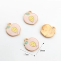 Detail view of 17mm peach pendants showing enamel finish and gold plated back texture - 17mmx16mm / Light Red Peach