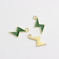 Detailed macro view of lightning bolt pendants with green enamel and gold finish texture - Green