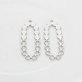 Macro detail of silver-tone hollow oval pendant with dot pattern for DIY jewelry making - Silver