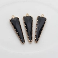 Detalle de tres colgantes triangulares negros facetados con borde dorado para joyería DIY - Negro