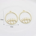 Detailed view of hollow eye charms with 39mm height and 35mm width measurements - Gilded Large
