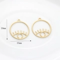 Detail view of 39x35mm gold hollow eye charms with eyelash accents for DIY jewelry - Matte Gold Large