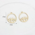 Detailed close-up of 25mm gold alloy evil eye pendants for jewelry making and crafting - Matte Gold Small