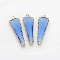 Primer plano de tres colgantes de cristal azul cobalto con bordes de metal dorado - Azul claro