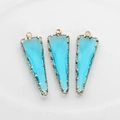 Detalle de colgantes de cristal azul claro triangulares con borde dorado claro - Azul lago