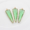 Detalle de tres colgantes triangulares de vidrio facetado verde claro con bordes dorados - Verde