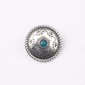 Dettaglio di un bottone concho vintage in argento con motivo solare e pietra turchese - Blu forato