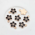 Detailed view of black enamel cherry blossom charms with gold-plated edges and ring - Black
