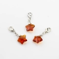 Detailed view of faceted amber crystal star pendants with silver lobster clasps - Brown