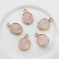 Detalle de cinco colgantes ovalados de piedra rosa facetada con borde dorado para joyería - Cuarzo rosa
