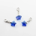 Three faceted dark blue crystal star charms with silver lobster clasps on white surface - Dark Blue