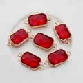 Close-up of six red rectangular faceted crystal charms with gold edges for jewelry making - Red