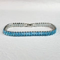 Macro view of blue rectangular zircon stones set in a gunmetal finish tennis bracelet - Platinum Color Aquamarine Zirconia Style