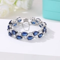 Silver bracelet with pear-cut deep blue stones and safety chain in 45-degree view - 17cm / Platinum Blue Zirconia