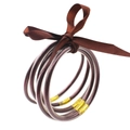 Detalle de cinco pulseras de silicona marrón con purpurina atadas con un lazo de raso marrón - Marrón