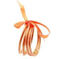 Primer plano de pulseras de silicona naranja con purpurina y un lazo de cinta de satén - Naranja