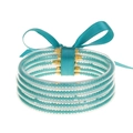 Primer plano de cinco pulseras flexibles de silicona con cuentas turquesas y puntas doradas - Cian