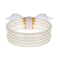 Detalle de brazaletes de silicona blanca rellenos de cuentas y un lazo decorativo - Blanco