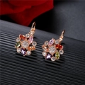 Orecchini a fiore con zirconi colorati e finitura in oro rosa su fondo scuro strutturato - Fiore Multicolore