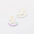 Macro shot of cartoon rocking horse pendants with colorful enamel coating for DIY jewelry - White Angel Horse