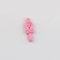 Close-up of pink enamel spoon charm with smiley face and bow for DIY jewelry making - Peach Pink