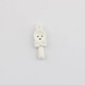 Close-up of a white lollipop DIY charm with a black smiley face and bow for jewelry - White