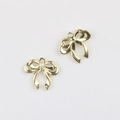 Macro-opname van twee gouden strikhangers met parel en oogje voor DIY-sieraden maken - Goud