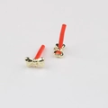 Detail view of golden alloy bowknot jewelry accessories with red cylinder drop pins - Gold