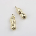 Primer plano de colgantes de cacahuete dorados con textura para joyería artesanal - Dorado