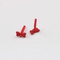 Macro detail of red bow-shaped DIY jewelry charms with matte finish and back pin - Red