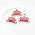 Vue détaillée de trois pendentifs demi-lune en agate rose avec bordure en métal doré - Rouge