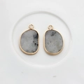 Macro shot of irregular grey agate pendants with gold plated edges for DIY jewelry making - Gray