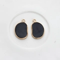 Macro shot of irregular black agate pendant with smooth gold plating and top hanging loop - Black