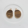 Detail view of irregular brown agate stone pendants with gold-plated metal edging - Brown