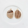 Macro detail of irregular natural stone pendants with gold metal edging for jewelry DIY - Wood Grain
