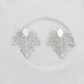 Macro view of silver hollow maple leaf charms with intricate filigree details for DIY jewelry - Silver