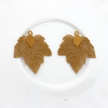 Detail of hollow maple leaf copper pendants with intricate mesh vein structure for DIY jewelry - Yellow