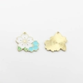 Detail of dual-color enamel cherry blossom charms with golden metal textured backing - White