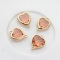 Detailed view of four peach heart crystal pendants with gold double-ring connectors - Peach