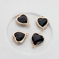 Close-up of four faceted black heart crystals with gold plated edges for DIY jewelry - Black