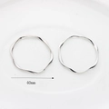 Detail of silver wavy hoop earrings featuring 40mm diameter with twisted metal texture - 40mm / Silver