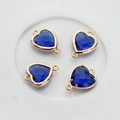 Close-up of four dark blue heart crystal pendants with gold copper edges and double loops - Dark Blue