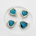 Macro shot of 13x18mm heart-shaped blue crystal pendants with double-sided facets and gold edges - Peacock Blue
