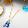 Collana dorata con ciondolo lettera R in smalto blu su sottobicchiere di marmo - Lettera R