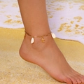 Close-up of golden starfish and white shell anklet on model's foot at the beach - Gold Chain White Shell Gold Starfish