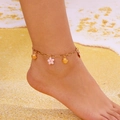 Golden starfish shell anklet detail with pink flower charm on sandy beach background - Gold Chain Pink Flower Gold Scallop