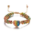 Detalle de pulsera artesanal con dije de corazón, cuentas de colores y cuerda boho - Arcoíris