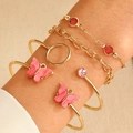 Detail of layered gold bracelets featuring daisy motifs and pink marble resin butterflies - Gold (7089)
